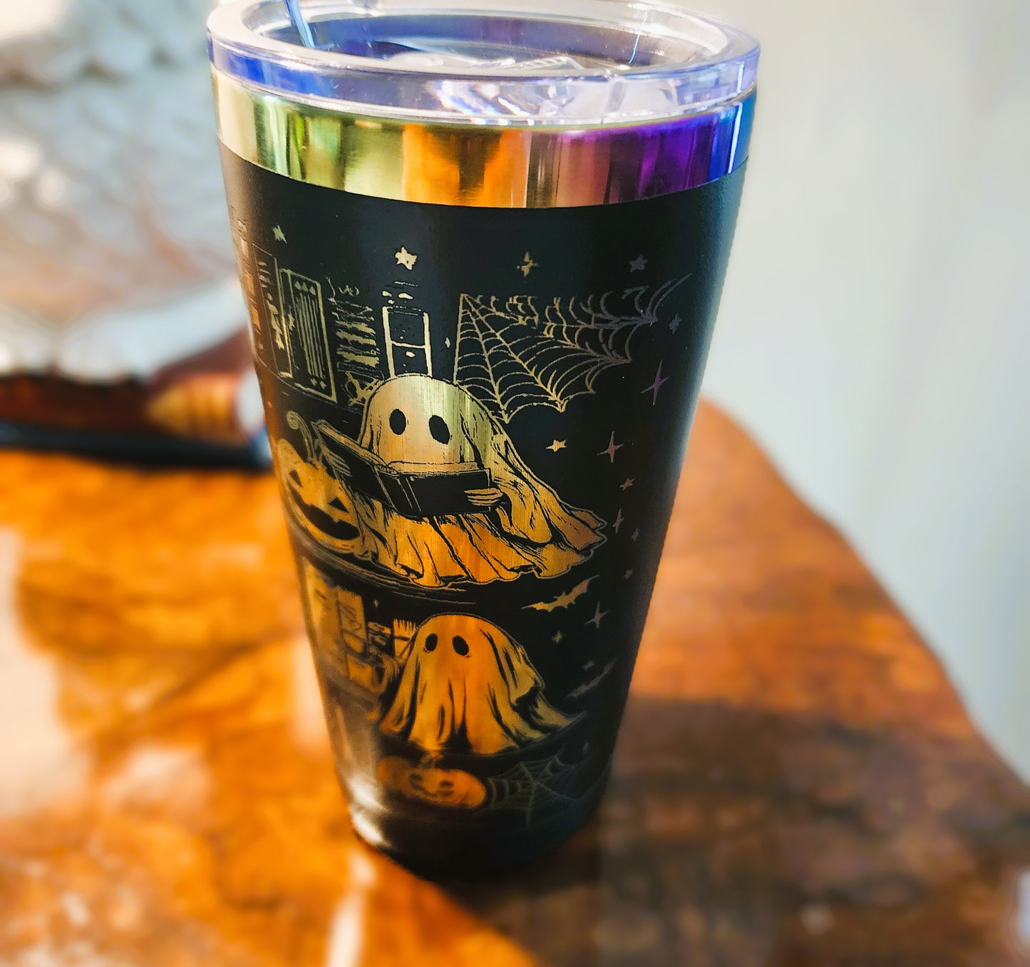 Tumbler with ghost design on a wooden surface