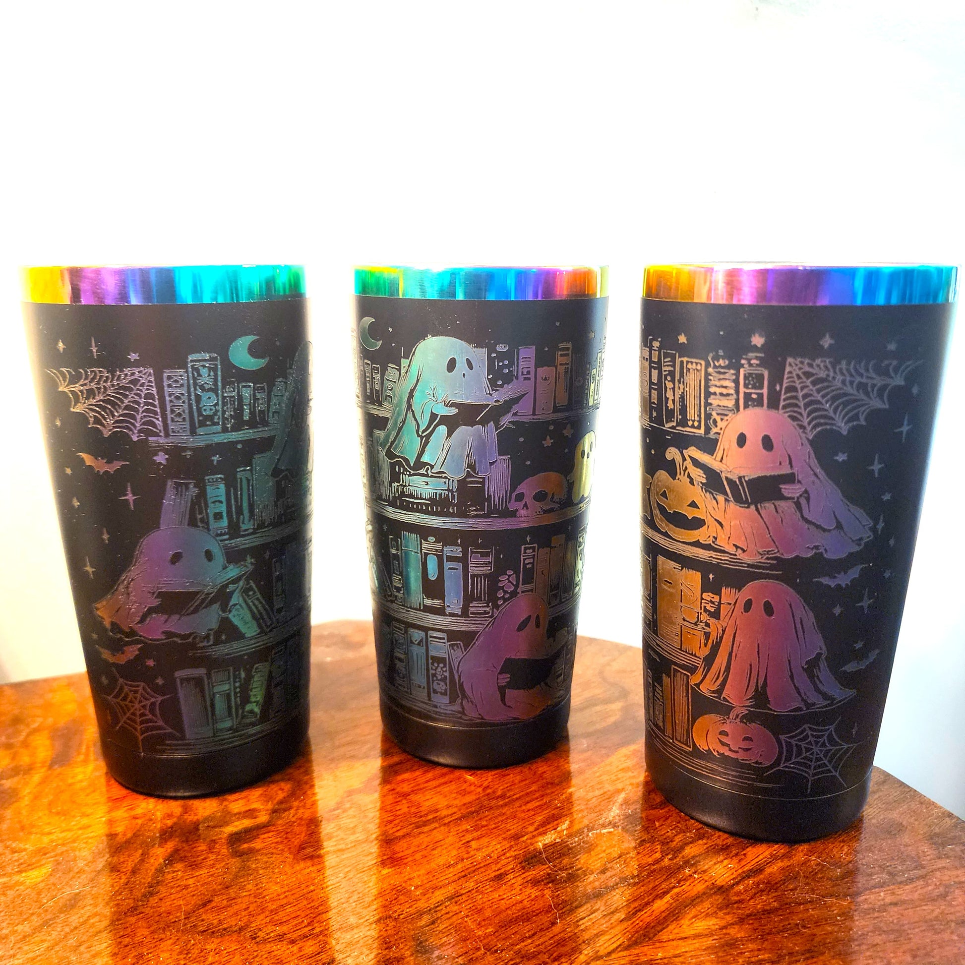 Three sides Halloween tumbler with colorful designs on a wooden surface